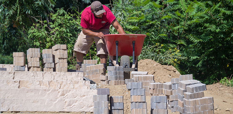 Worker installing pavers stones